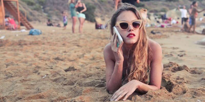 Nainen puhu puhelimessa rannalla